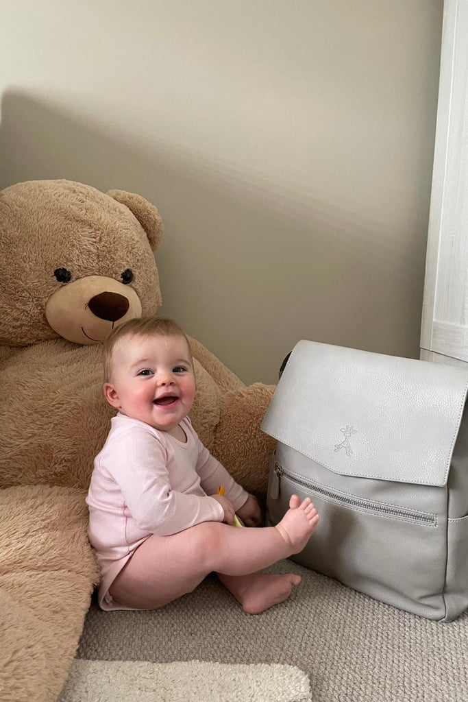 Baby in nursery with grey vegan leather diaper backpack 