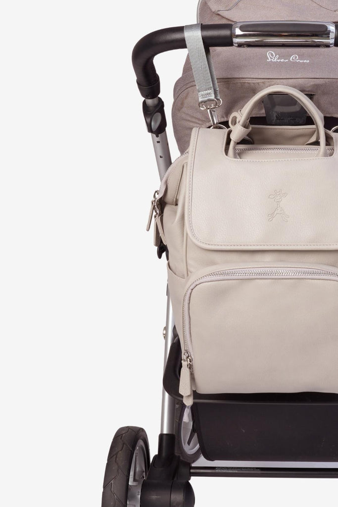 Grey vegan leather baby changing backpack hanging on pram with pram clips 