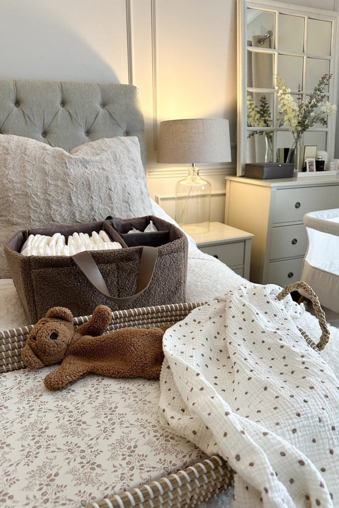 Brown teddy fleece diaper caddy on a bed next to a changing mat 