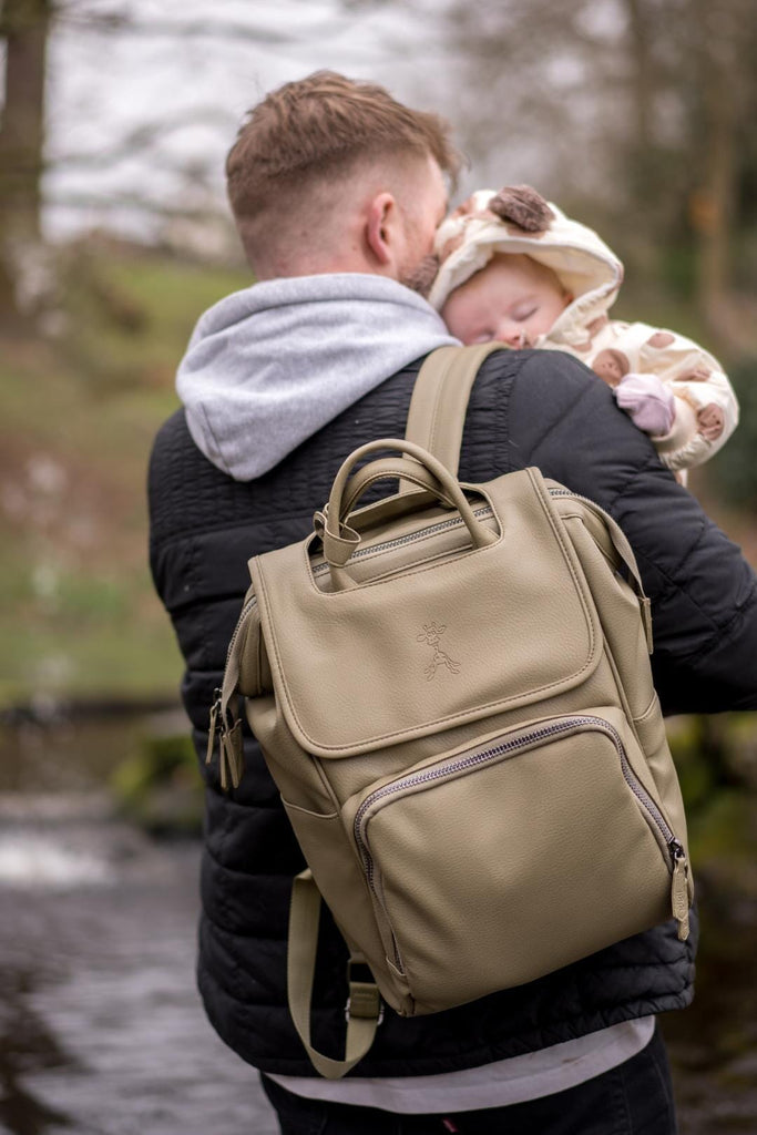 Dad holding baby with olive green vegan leather diaper backpack 