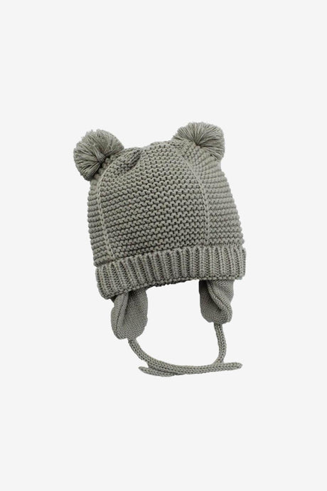 Green knit baby bobble hat on white background