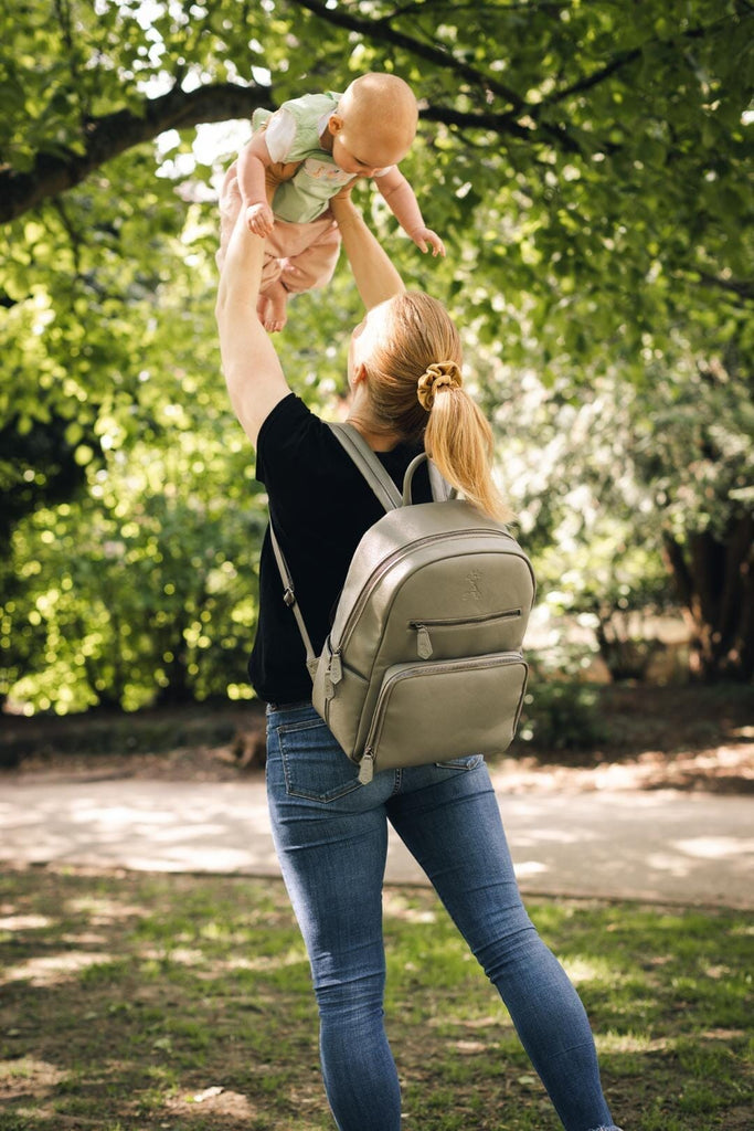 Mum holding a baby wearing bloom vegan leather diaper backpack 