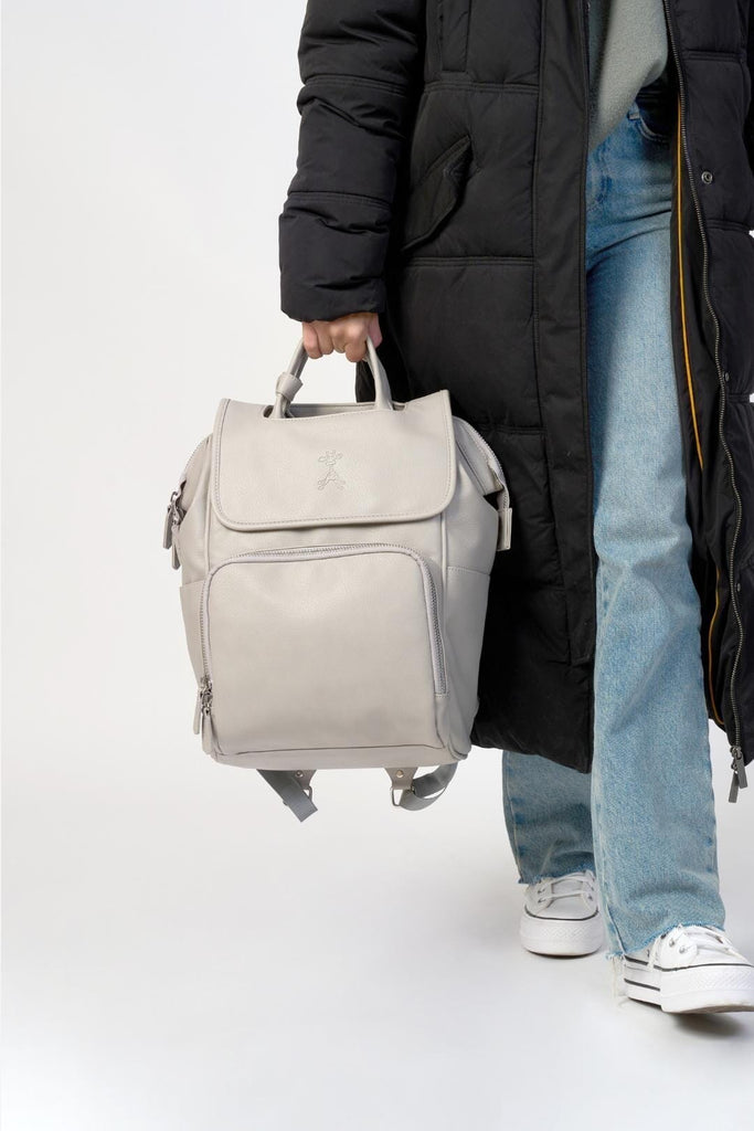 Mum holding vegan leather diaper backpack with top handles 