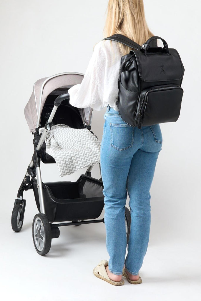 Mum wearing black vegan leather baby changing backpack 