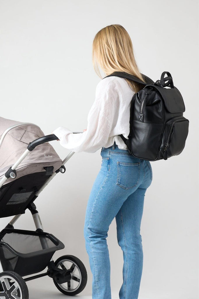 Mum wearing black vegan leather diaper backpack