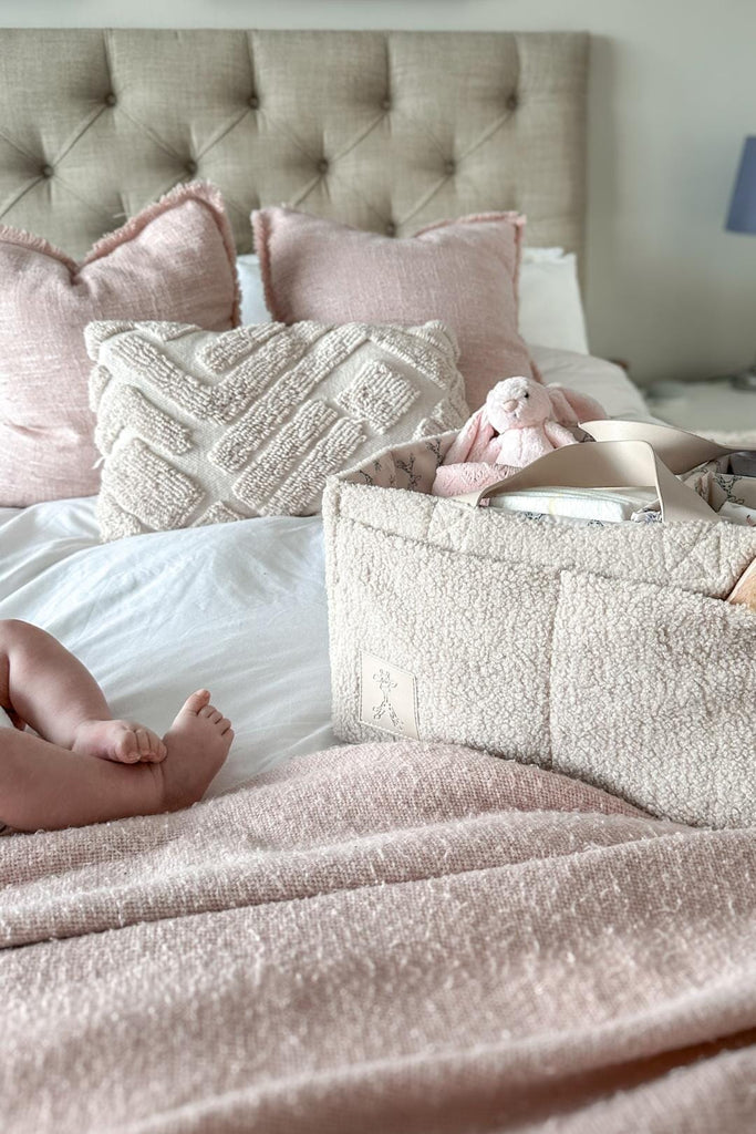 Cream teddy nappy caddy with vegan handles on a bed 