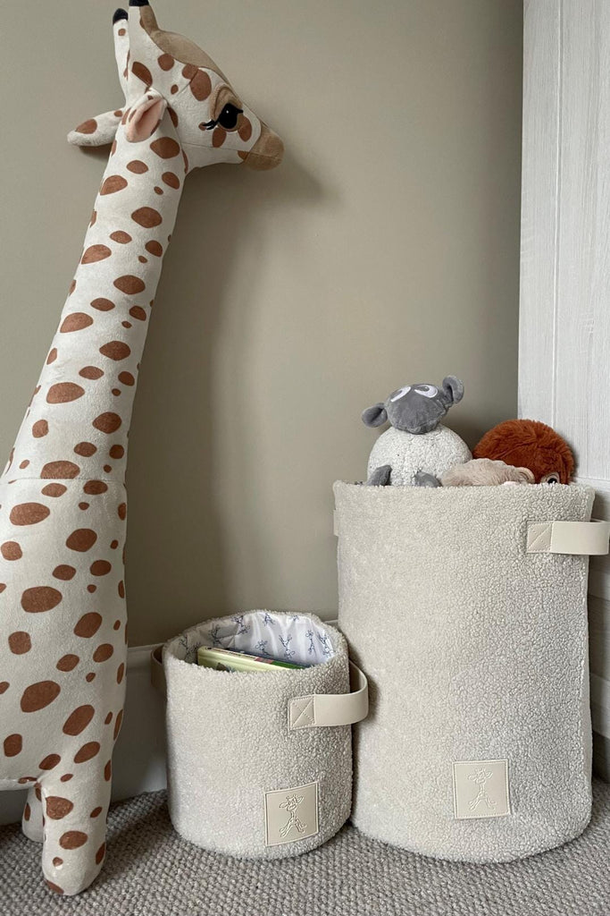 Set of two beige teddy fleece storage baskets in a nursery