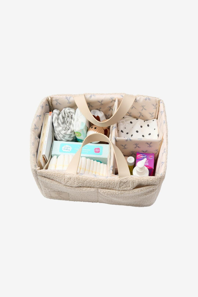 Cream teddy nappy caddy with vegan leather handles filled with baby essentials 